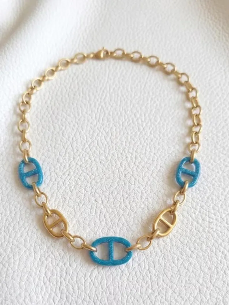 Collier chaîne dorée maillons grain de café résine bleu ciel - vue posée
